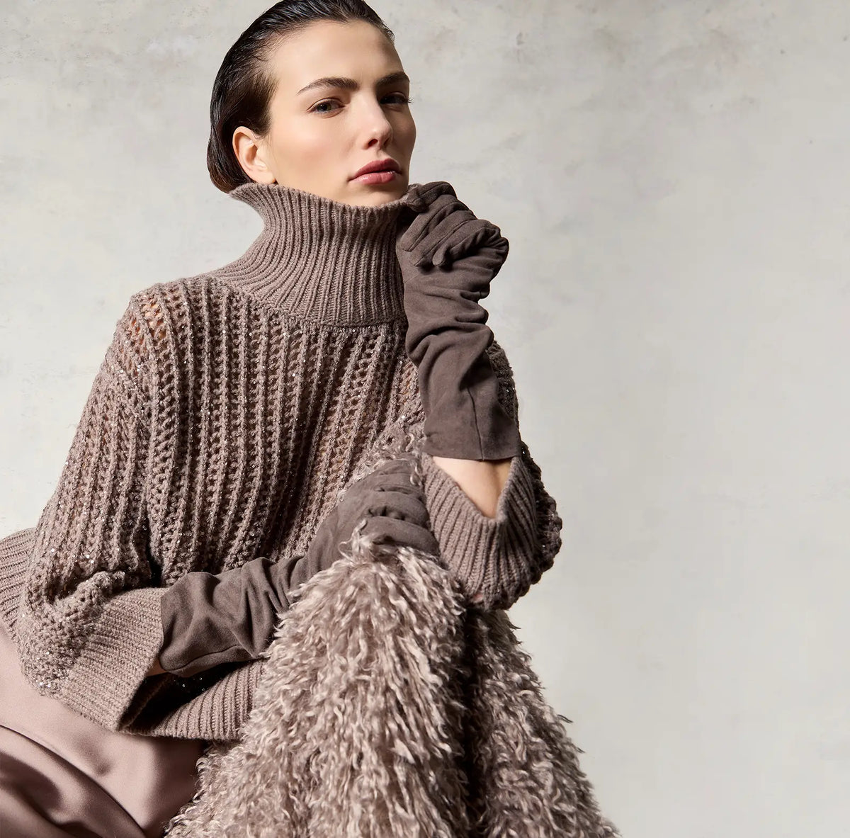 Modella con maglione dolcevita lavorato a trecce e guanti lunghi D-Exterior