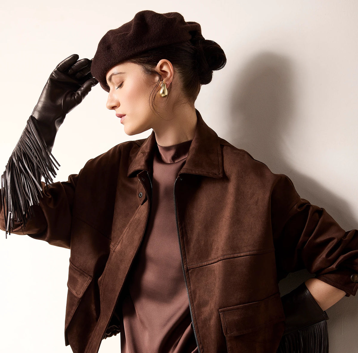 Modella con giacca marrone effetto pelle e cappello D-Exterior